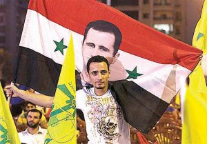 ...Un manifestante ta mustra e bandera ku un otret di e presidente Bashar Assad... 